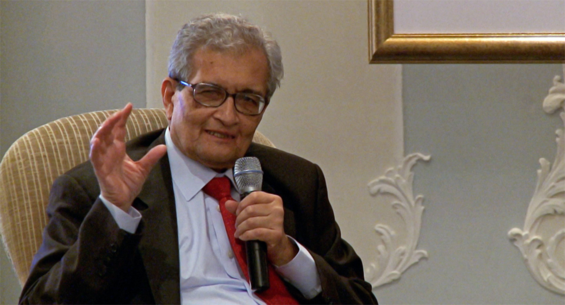Amartya Sen Disparity Film Still, Amartya Sen speaking with microphone
