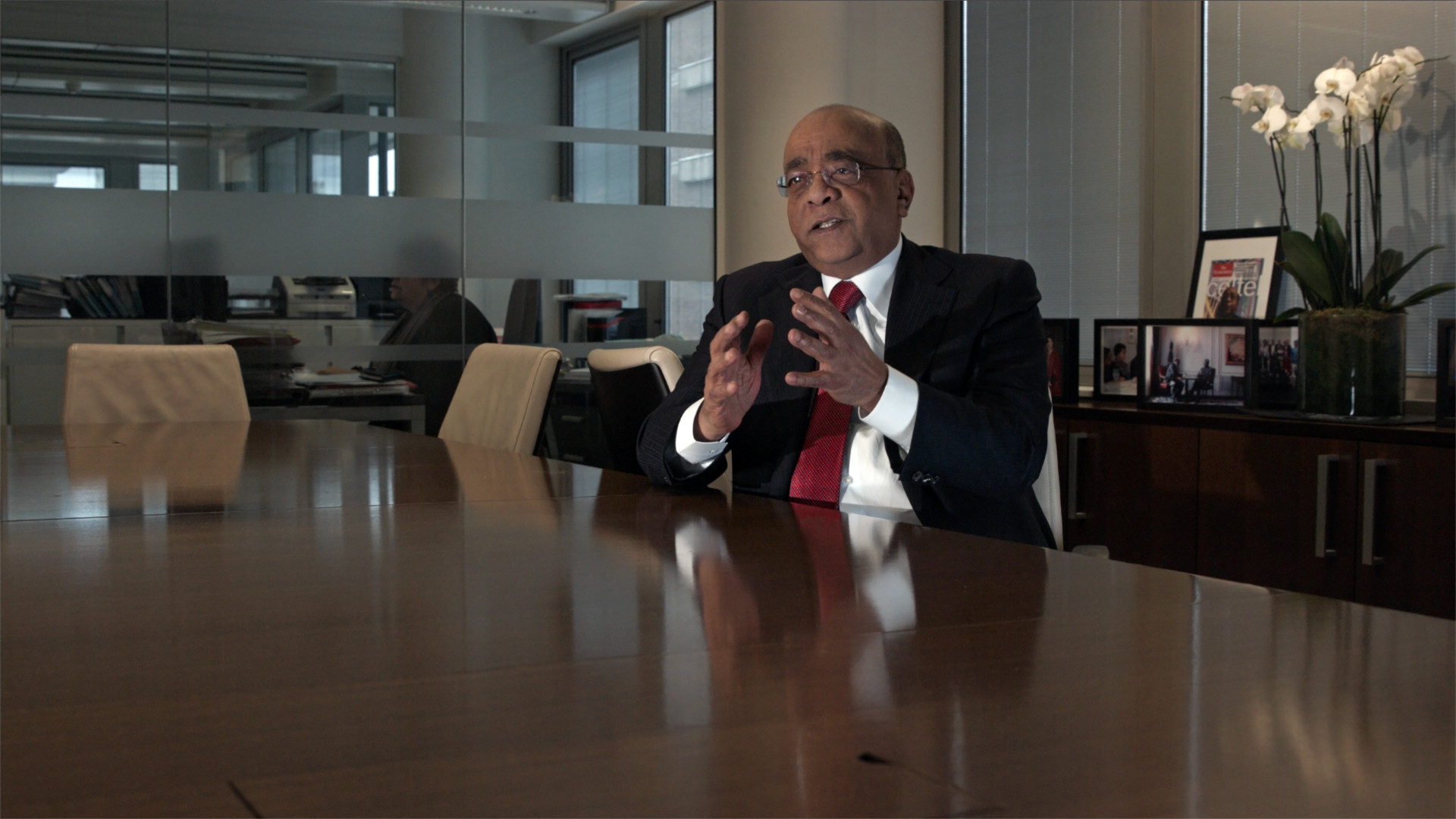 Dr. Mo Ibrahim Disparity Film Still, Dr Mo Ibrahim sitting at desk