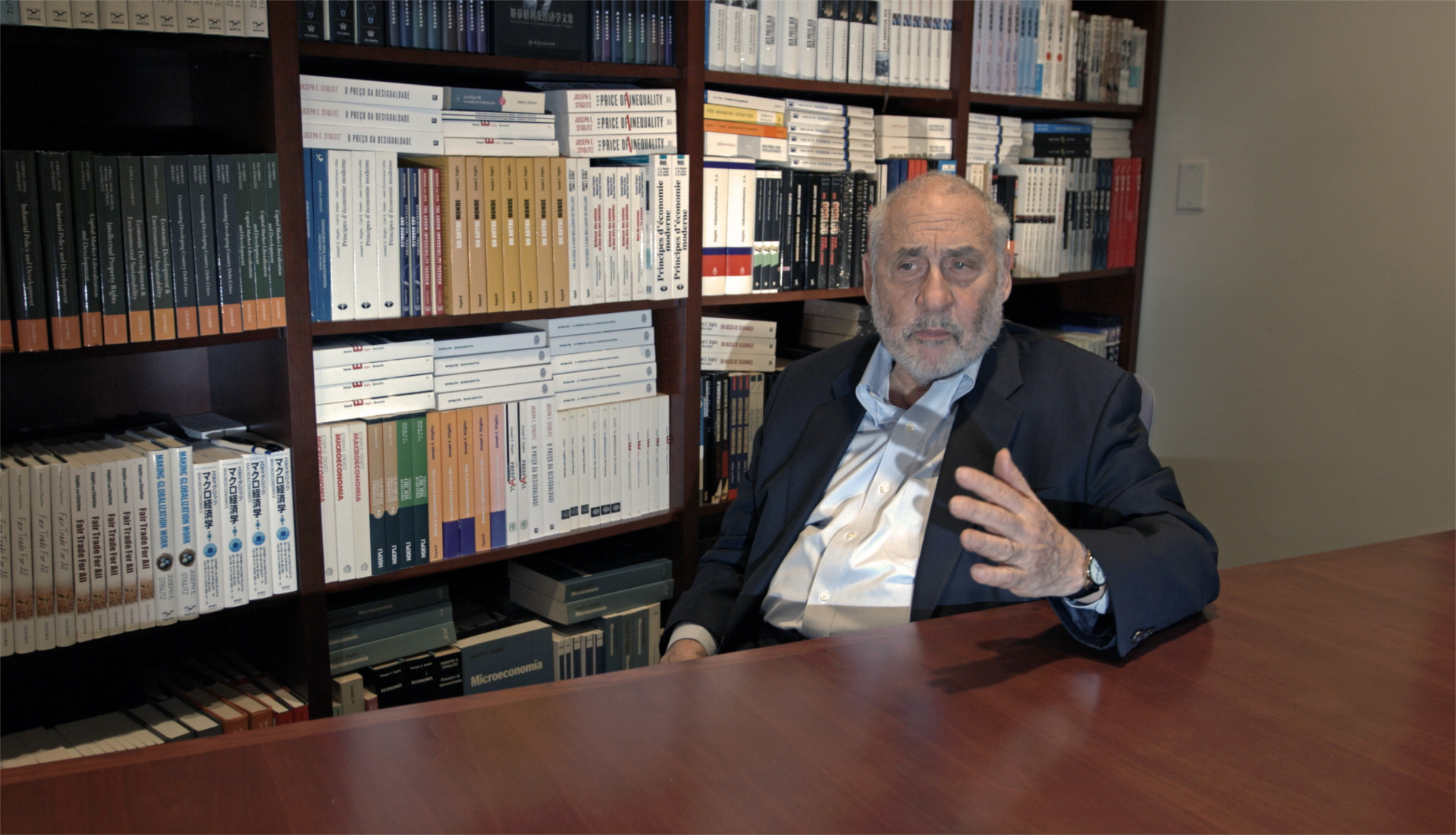 Joseph Stiglitz Disparity Film Still, Joseph Stiglitz sitting in front of bookshelf