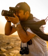 Conflict photographer Younes Mohammad looking through camera